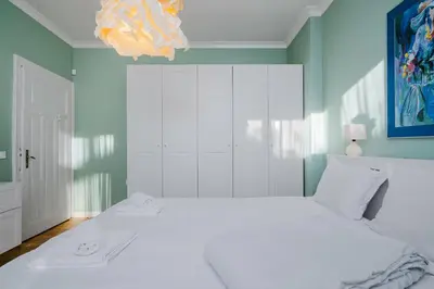 a bedroom with a white bed and a blue wall at Charming 1BD Apartment Next to Women's Market by Flat Mаnager in Sofia