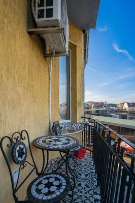 a patio with a table and chairs on a balcony at Charming 1BD Apartment Next to Women's Market by Flat Mаnager in Sofia