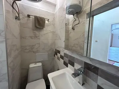 a bathroom with a toilet and a sink and a mirror at Cozy Stay Sofia Historic Center in Sofia