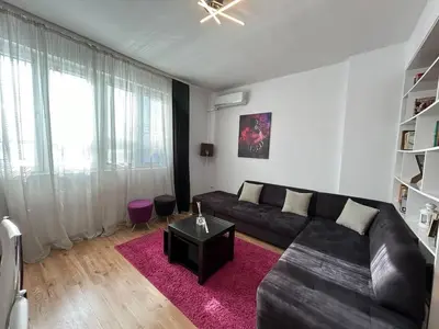 a living room with a black couch and a pink rug at Cozy Stay Sofia Historic Center in Sofia