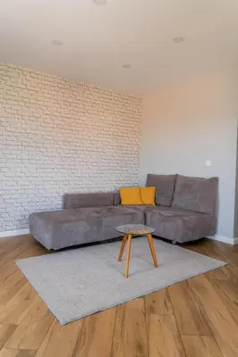 a living room with a couch and a table at Апартамент с люлка и гледка в The House с Термална зона in Velingrad