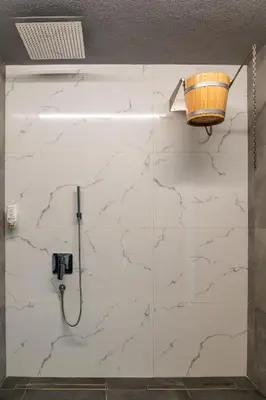 a bathroom with a white marble wall at Апартамент с люлка и гледка в The House с Термална зона in Velingrad