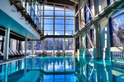 a large swimming pool with blue water in a building at Alpine Charm Borovets Apart in Borovets