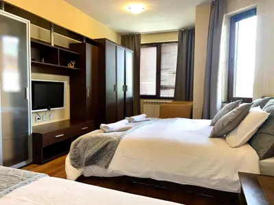 a bedroom with two beds and a flat screen tv at Slope nest Bansko in Bansko
