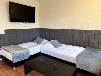 a hotel room with two beds and a flat screen tv at Slope nest Bansko in Bansko