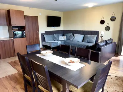 a living room with a table and a couch at Slope nest Bansko in Bansko