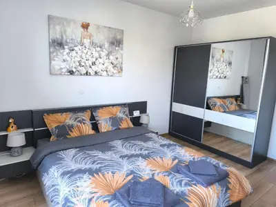 a bedroom with a large bed and a mirror at Апартамент Славяна in Velingrad