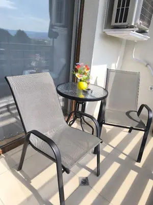 two chairs and a table on a balcony at Апартамент Славяна in Velingrad