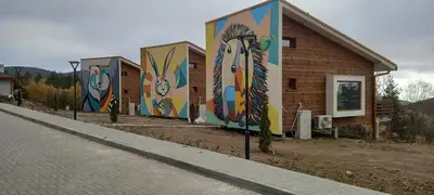 a row of houses with paintings on the side of them at ЕКО Къщи Марциганица in Dobrostan