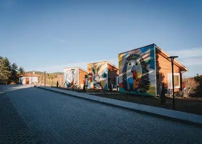 a building with paintings on the side of it at ЕКО Къщи Марциганица in Dobrostan