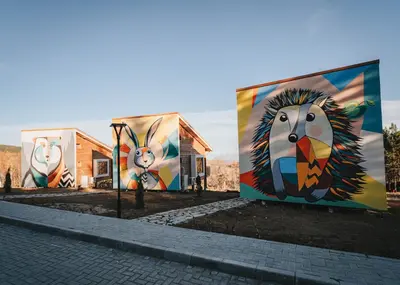 a building with paintings on the side of it at ЕКО Къщи Марциганица in Dobrostan