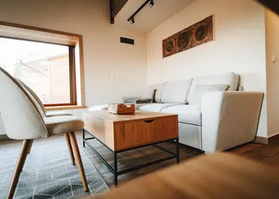 a living room with a couch and a table at ЕКО Къщи Марциганица in Dobrostan