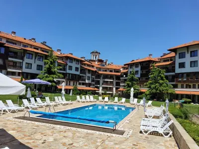 a swimming pool with lounge chairs and a hotel at Bansko Royal Towers apartment Star in Bansko