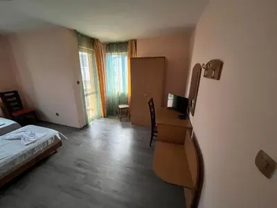 a bedroom with a bed and a desk with a computer at Hotel MERIDA in Blagoevgrad