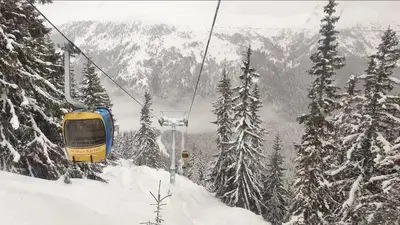 a yellow and blue train on a ski lift in the snow at Hotel MERIDA in Blagoevgrad