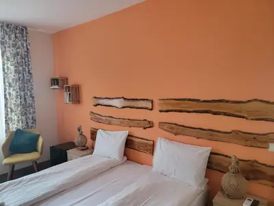 a hotel room with a bed and a chair at Стаи за гости Писателите in Hisarya