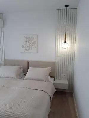 two beds in a room with white walls at Villa Vitosha Apartments in Hisarya