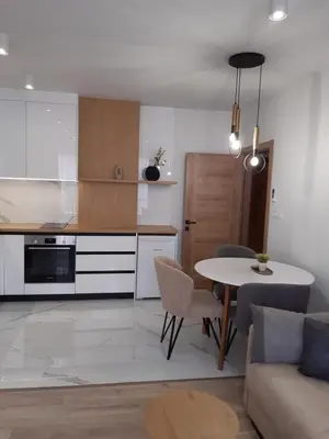 a kitchen and living room with a table and a couch at Villa Vitosha Apartments in Hisarya
