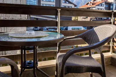 a table and chairs on a balcony with a fountain at Silver Ridge Studio by SI Stay in Razlog