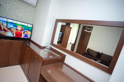 a living room with a television and a mirror at Mon Ami Apart in Studentski Grad Area in Sofia
