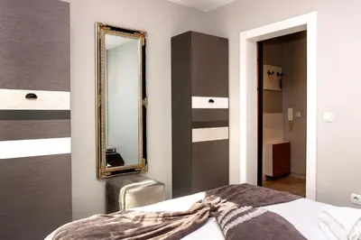 a bedroom with a mirror next to a bed at Mon Ami Apart in Studentski Grad Area in Sofia