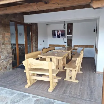 a dining room with a wooden table and chairs at Вила Анжелика in Ilinden
