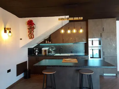 a kitchen with a counter and some stools in it at Вила Анжелика in Ilinden