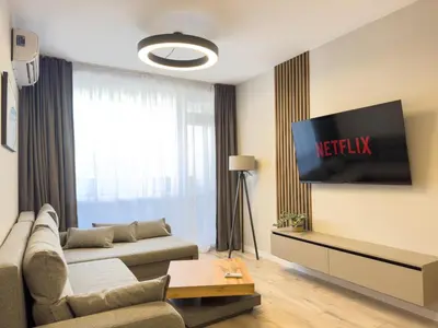 a living room with a couch and a television at Modern & Spacious Two-Bedroom Apartment in Plovdiv