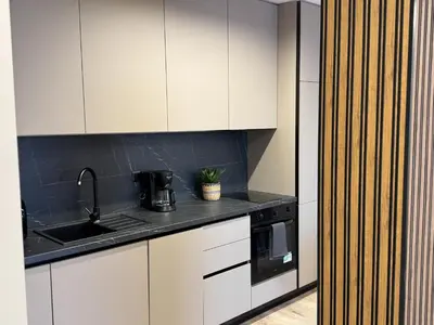 a kitchen with white cabinets and a sink at Modern & Spacious Two-Bedroom Apartment in Plovdiv