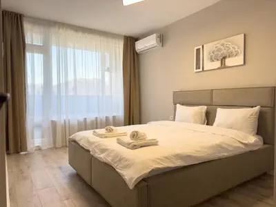 a bedroom with a bed with two towels on it at Modern & Spacious Two-Bedroom Apartment in Plovdiv