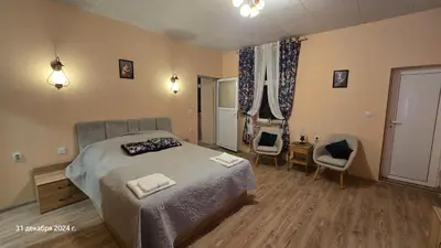 a bedroom with a bed and two chairs in it at Suite Roma 3 in Velingrad