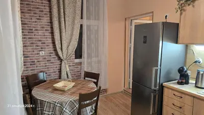 a kitchen with a table and a refrigerator at Suite Roma 3 in Velingrad