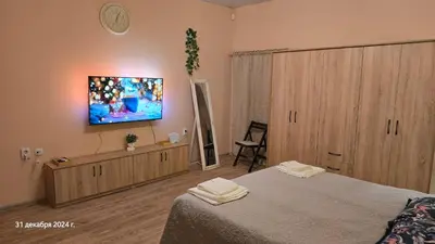 a bedroom with a bed and a tv on the wall at Suite Roma 3 in Velingrad