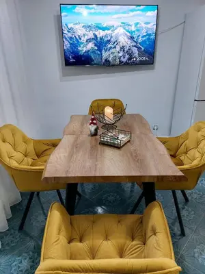 a wooden table with two yellow chairs in a room at Tsvetanov Apartment in Blagoevgrad
