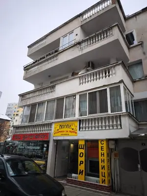 a building on a street with cars parked in front of it at Tsvetanov Apartment in Blagoevgrad