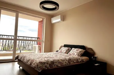 a bedroom with a bed and a large window at New apartment with a great view in Sofia