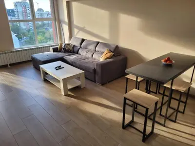 a living room with a couch and a table at New apartment with a great view in Sofia