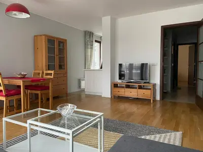 a living room with a glass table and a television at Blavka apartment Gardenia in Sofia