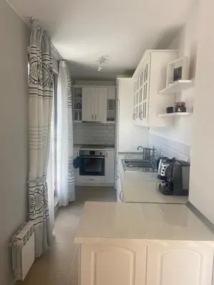 a kitchen with white cabinets and a counter top at Blavka apartment Gardenia in Sofia