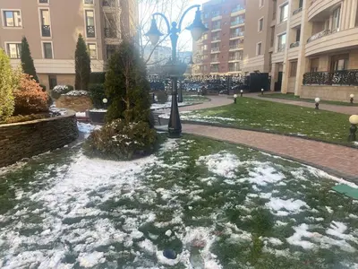 a park with snow on the grass and a street light at Blavka apartment Gardenia in Sofia