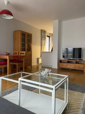 a living room with a glass table and a tv at Blavka apartment Gardenia in Sofia