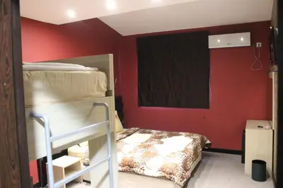 a bedroom with a bunk bed and red walls at Guest House Veni in Blagoevgrad
