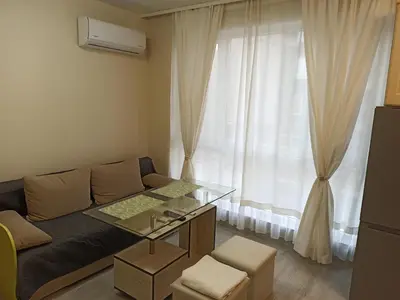 a living room with a couch and a window at Апартамент тип хотелска стая in Plovdiv