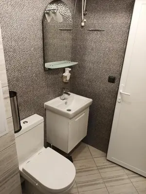 a bathroom with a toilet and a sink and a mirror at Апартамент тип хотелска стая in Plovdiv