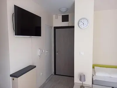 a room with a door and a clock on the wall at Апартамент тип хотелска стая in Plovdiv