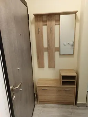 a bathroom with a wooden cabinet and a mirror at Апартамент тип хотелска стая in Plovdiv