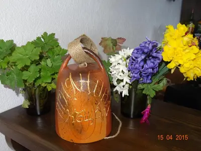 an orange jug sitting on a table with flowers at Ognyanovata Guest House in Dobărsko