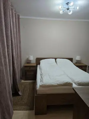 a bedroom with a bed and two night stands and two lamps at Костадинов 2 in Pamporovo
