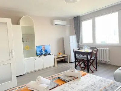 a living room with a television and a table at Magnolia city view studio in Sofia