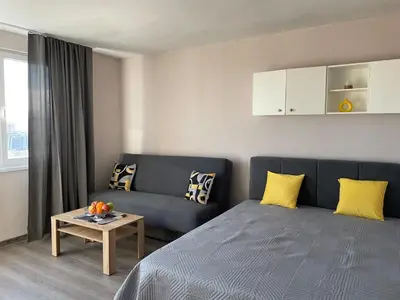 a room with a bed and a couch and a table at Magnolia city view studio in Sofia